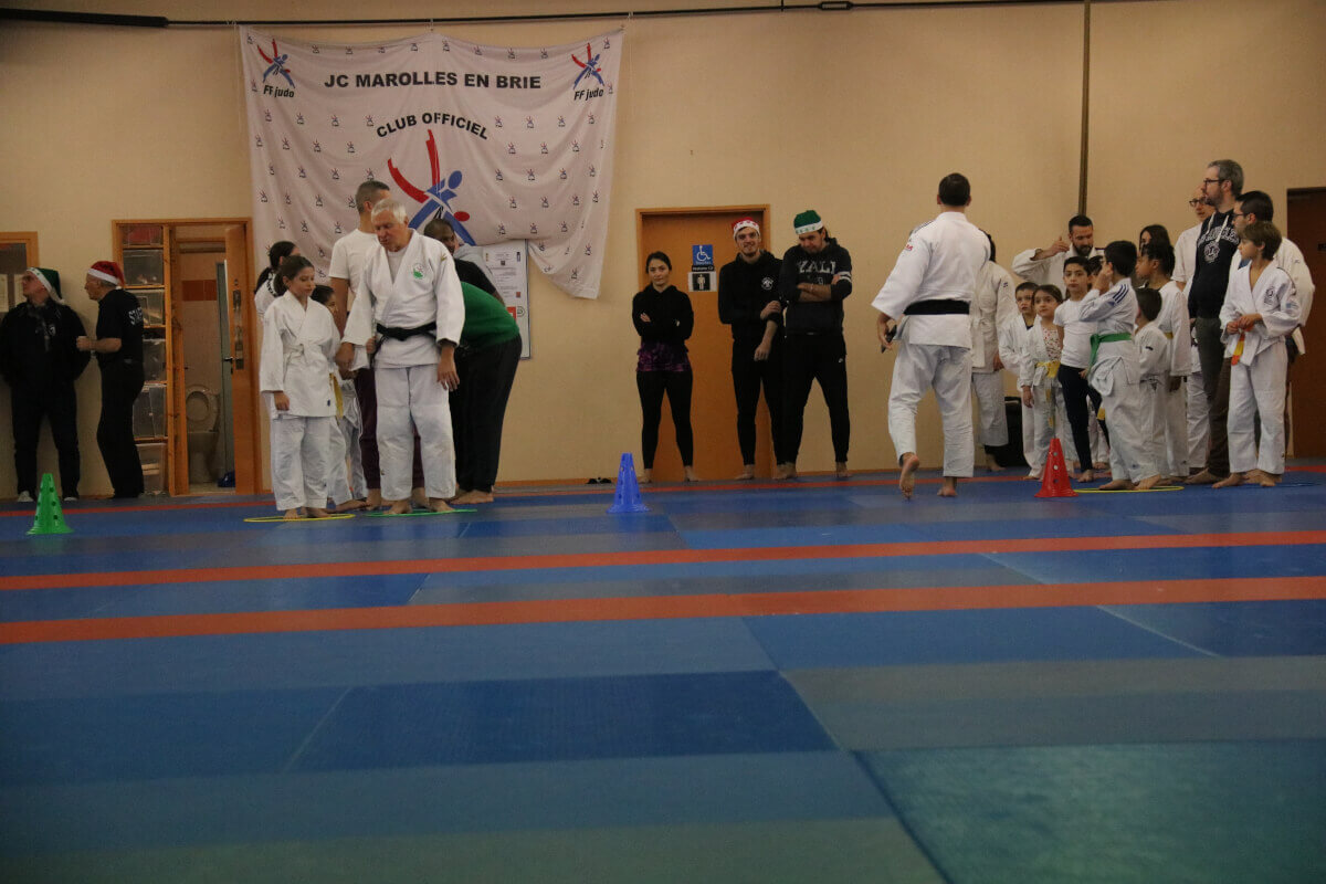 Photo de groupe réunissant tous les participants du dojo, jeunes et adultes, posant fièrement en tenue de judo.