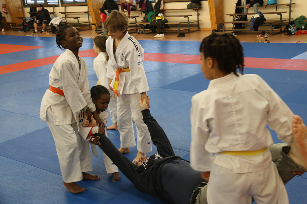 Grande photo de groupe prise au Dojo Family 2024, avec tous les judokas et leurs familles réunis sur le tatami.