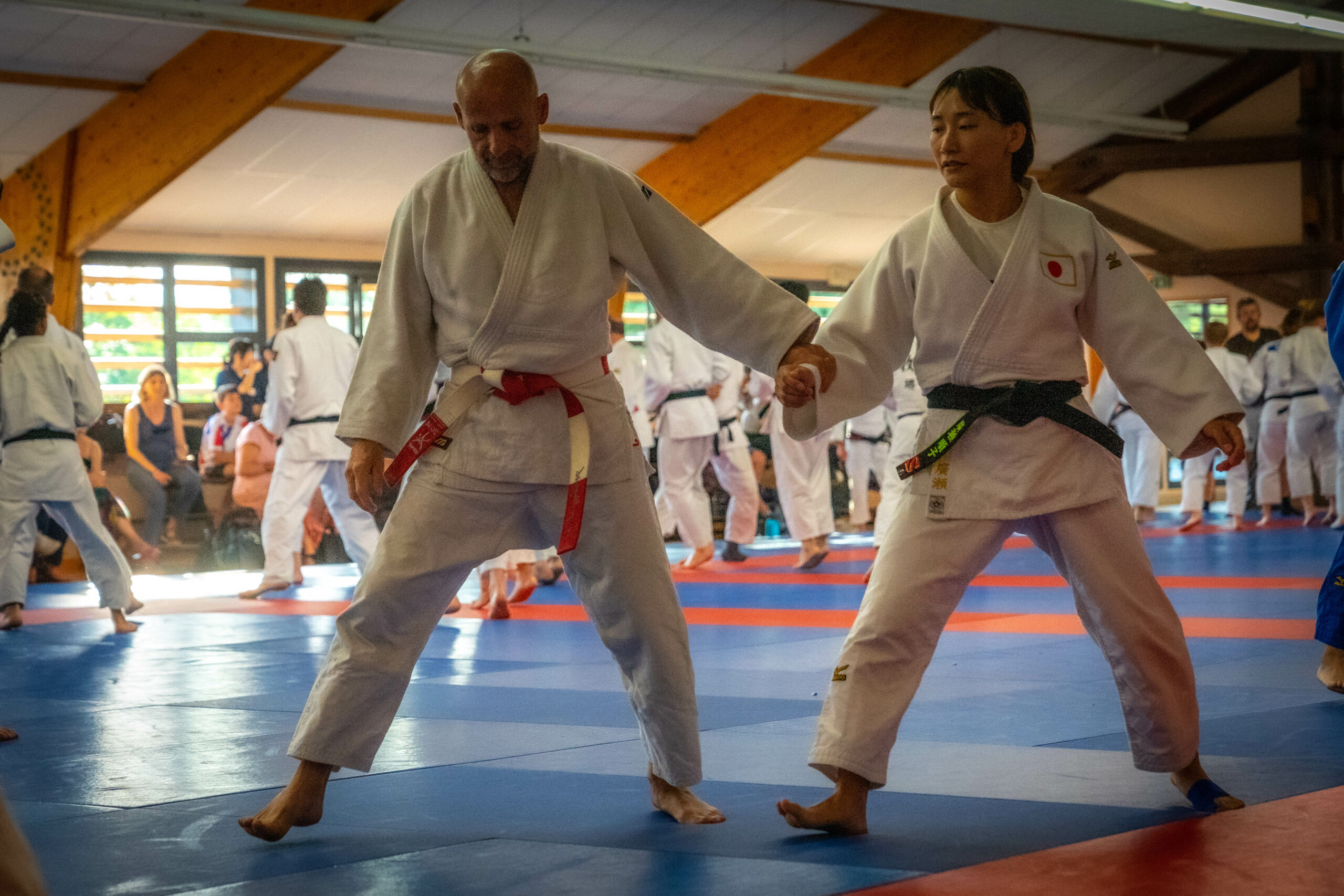 Instructeur de judo ceinture rouge pratiquant avec un élève lors d'une séance.