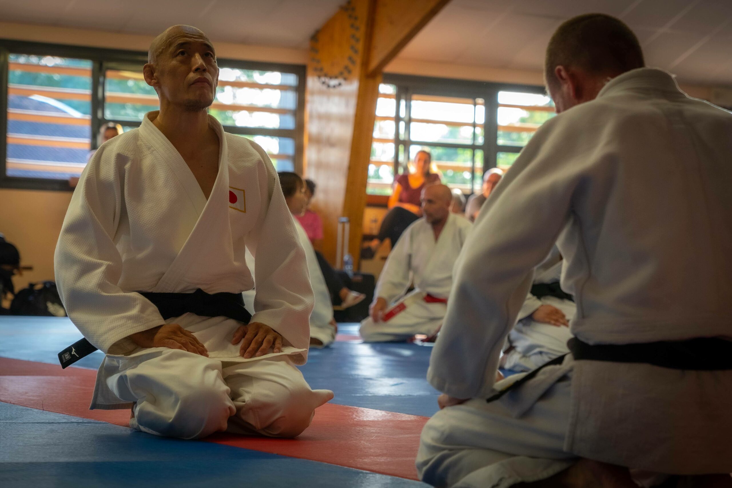 Judoka assis en seiza, concentré avant un exercice de judo.