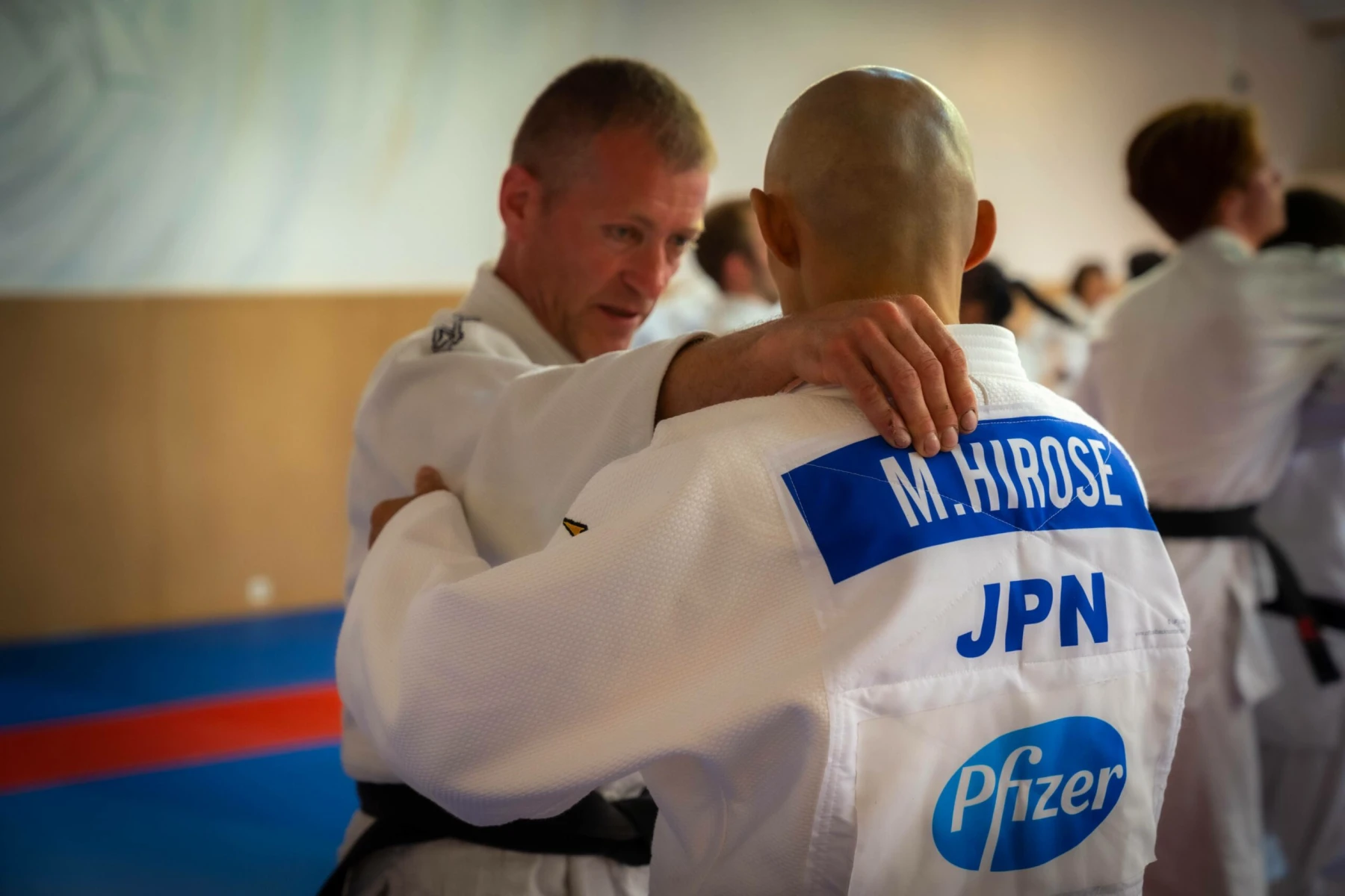 Deux judokas s'entraînant, un judoka japonais avec 'M. Hirose' sur le dos.