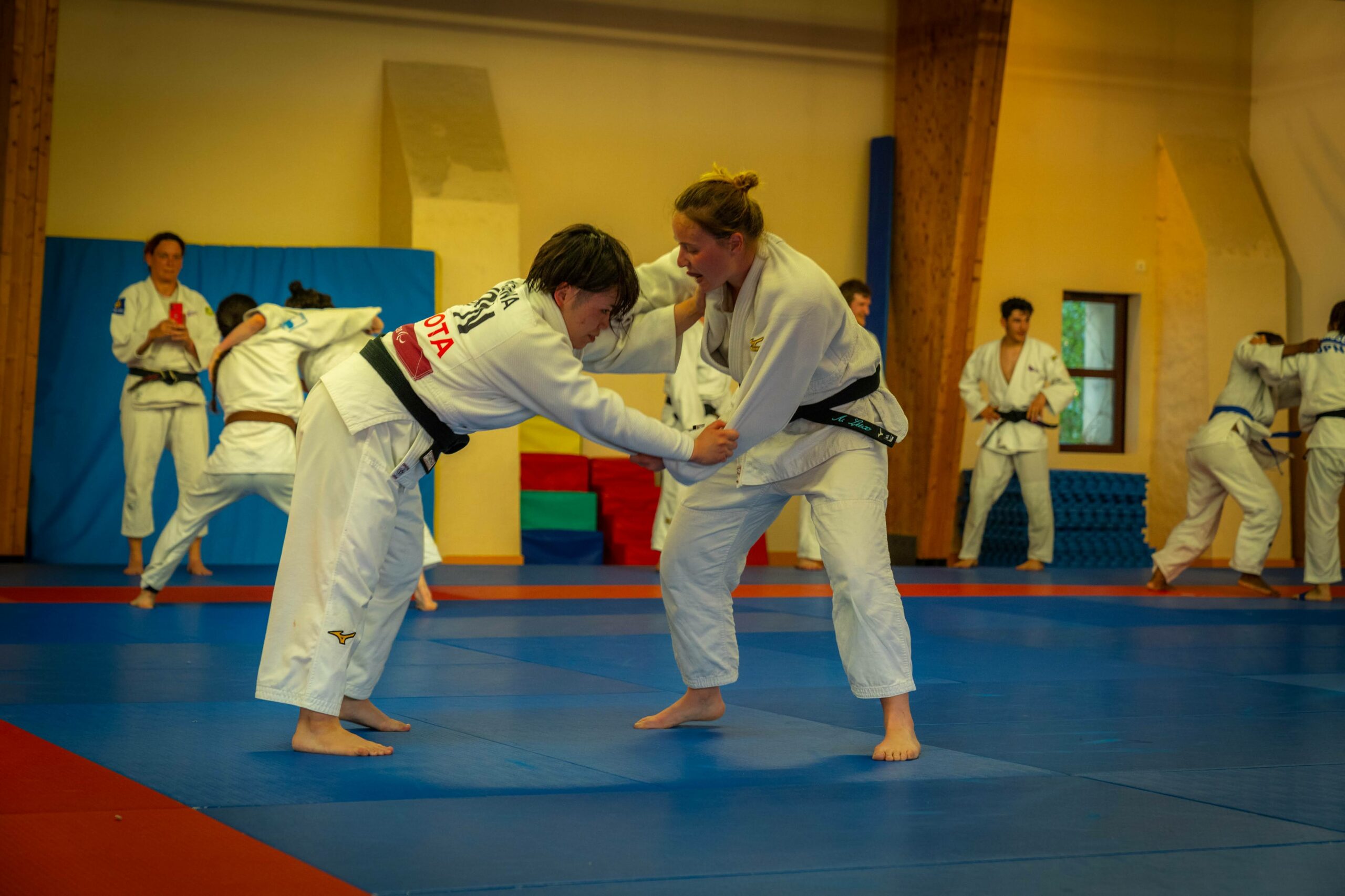 Judokas en plein combat d'entraînement dans le dojo.