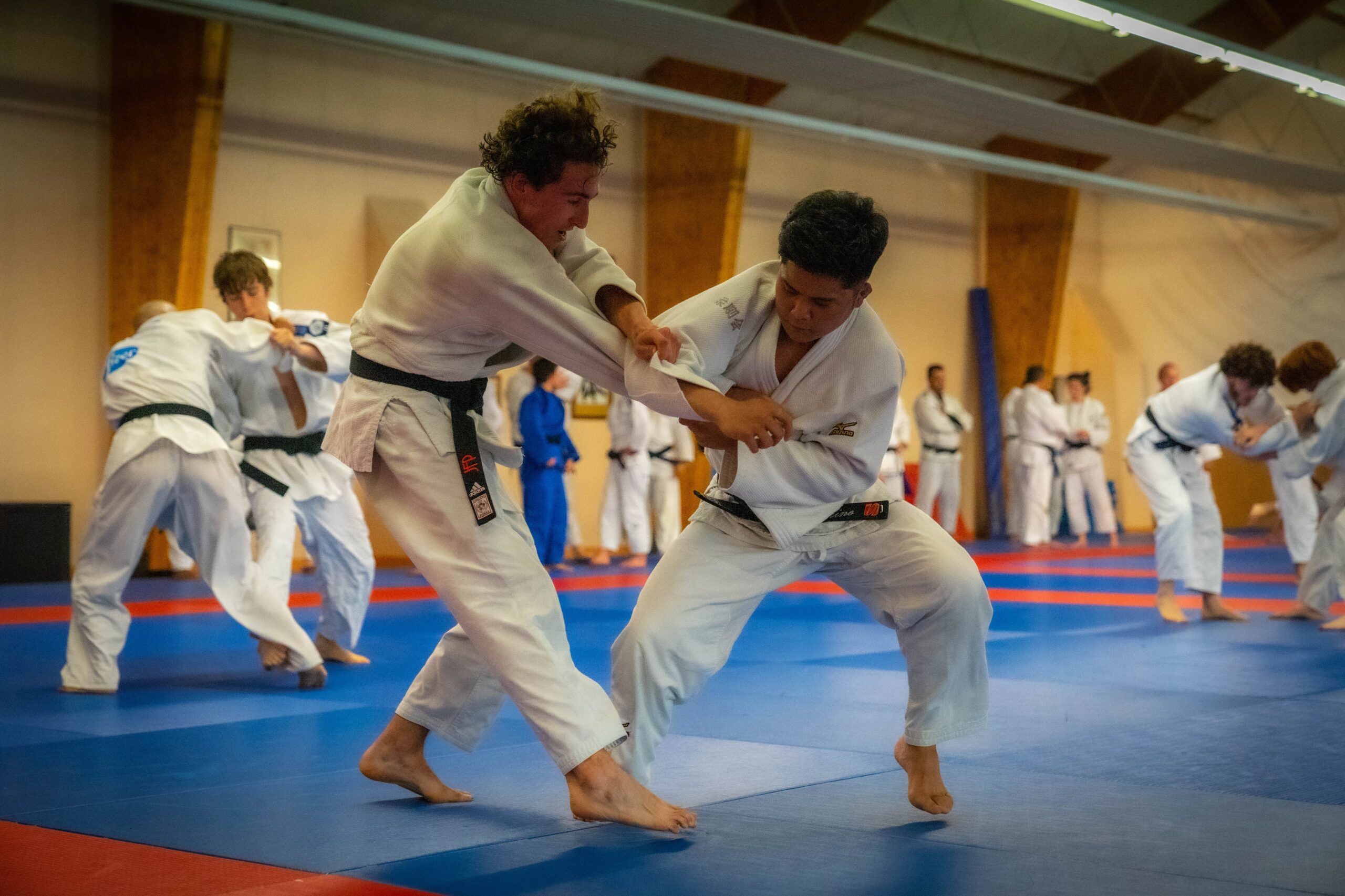 Deux jeunes judokas s'affrontant sur le tatami durant une session technique.