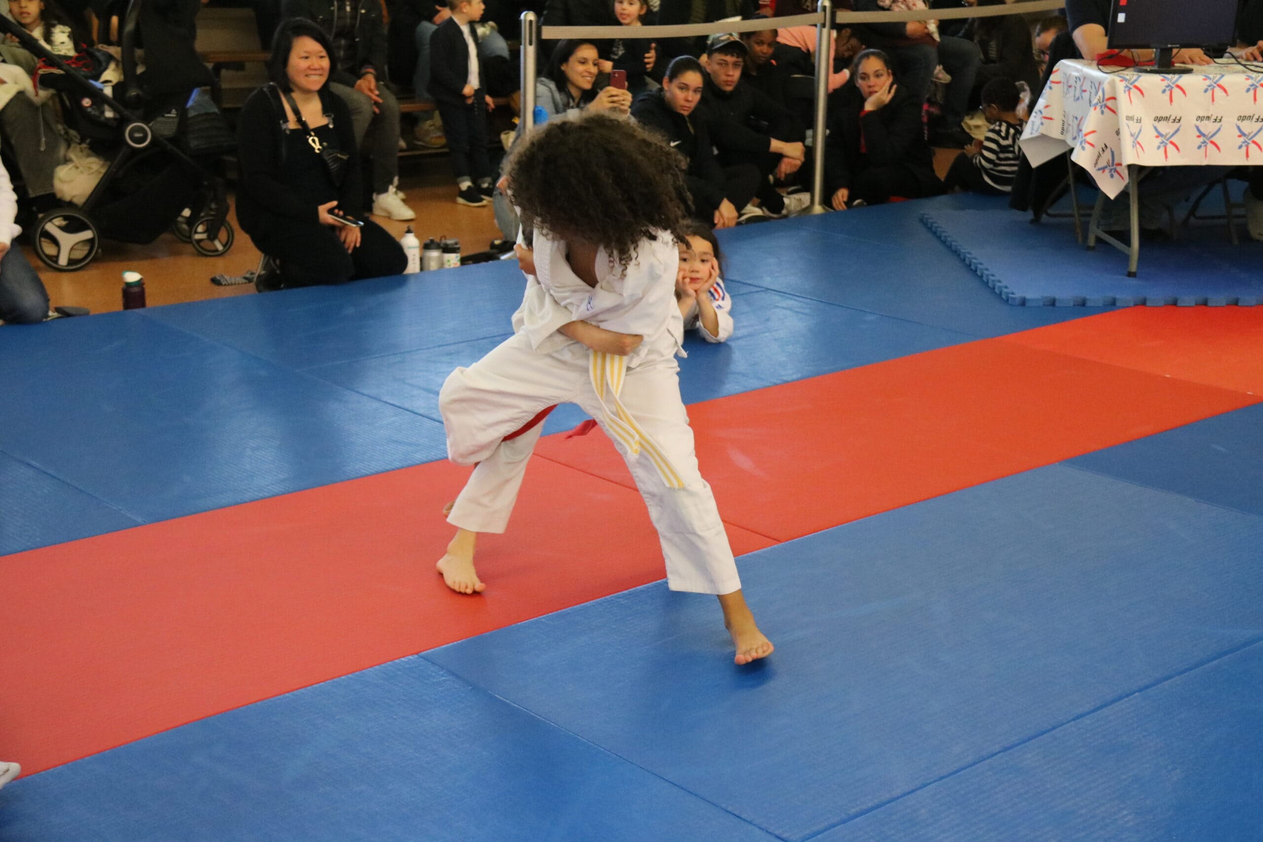 Judoka concentrée sur un exercice de démonstration sur le tatami.