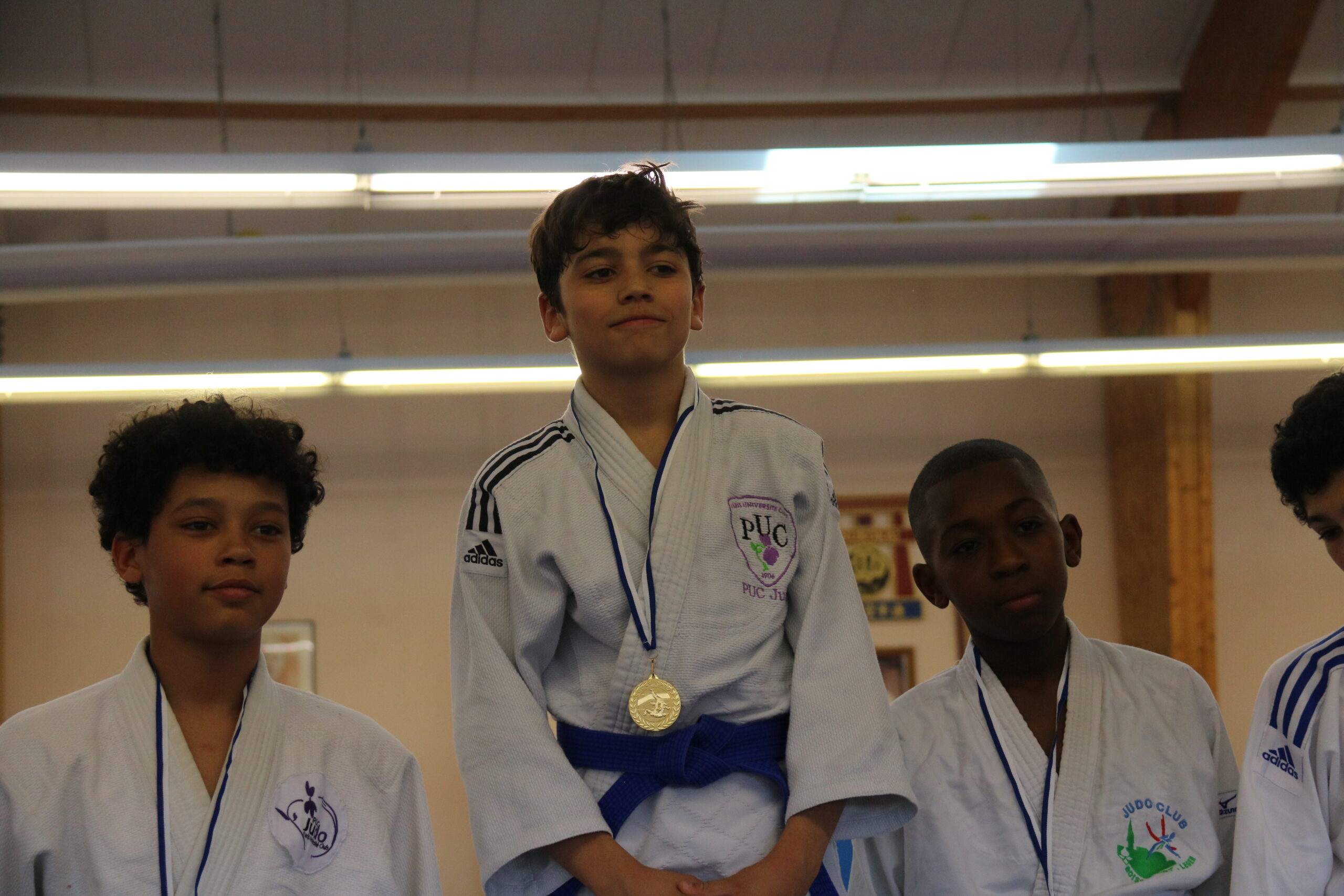 Jeune judoka recevant une médaille sur le podium après une victoire.