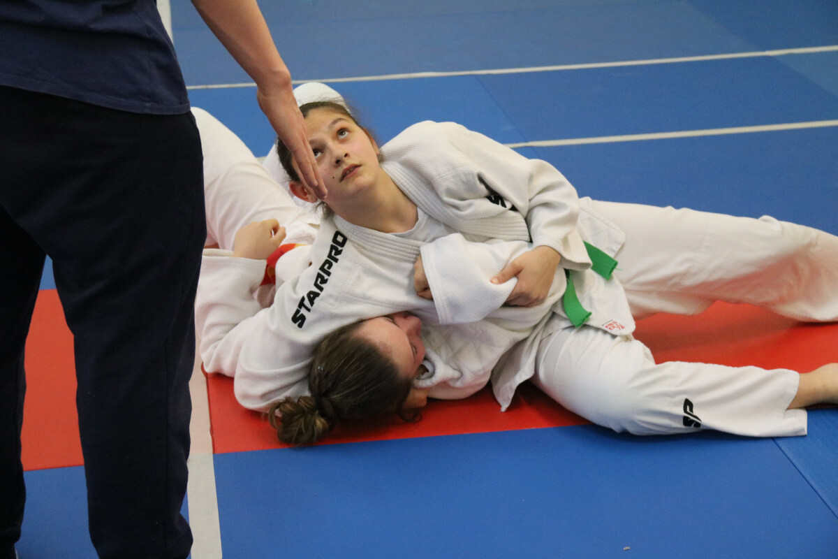 Enfants judokas assis en attente pendant une compétition ou une démonstration au club.