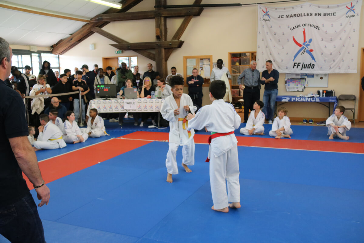 Enfants judokas exécutant un échauffement dynamique pendant l'entraînement de judo.