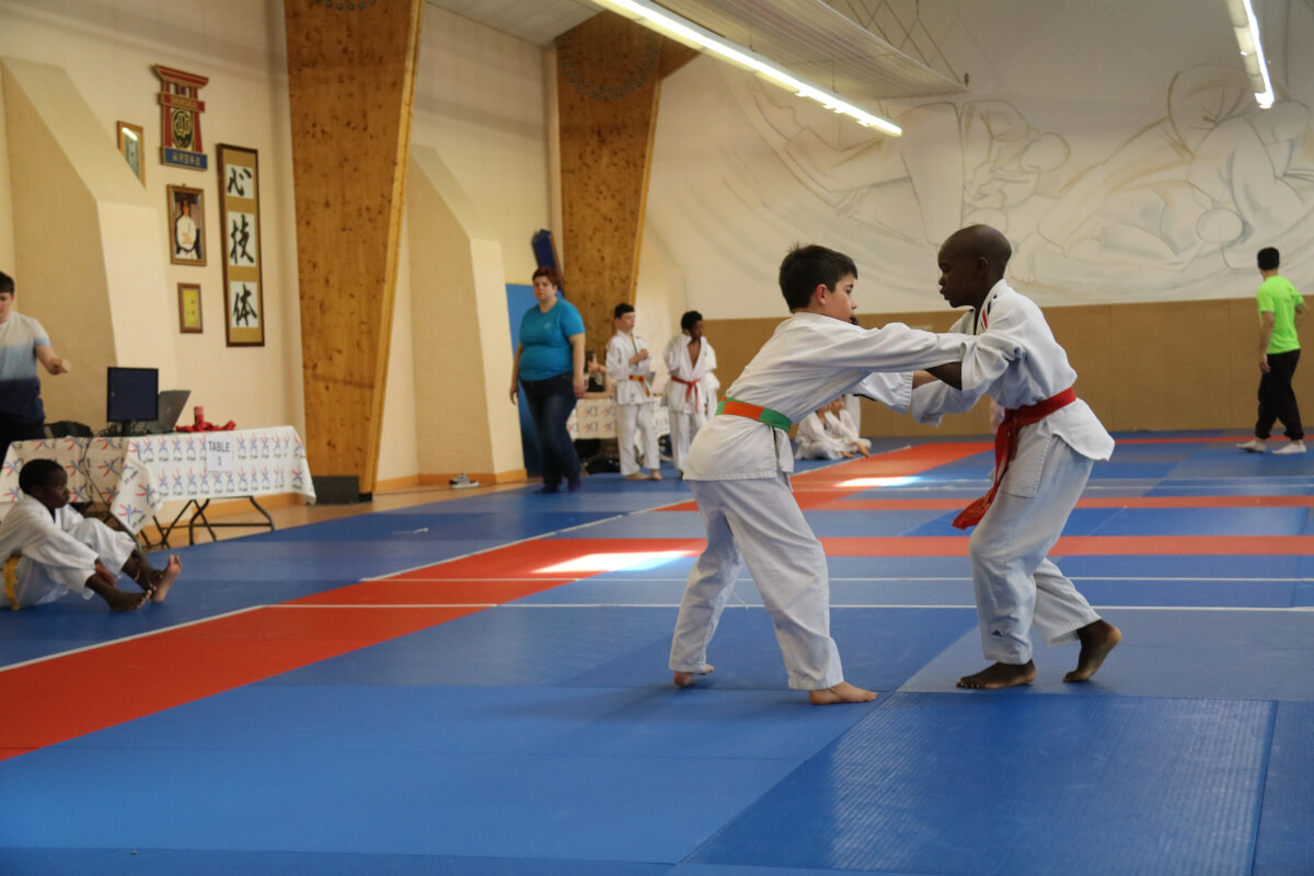 Judoka concentrée sur un exercice de démonstration sur le tatami.